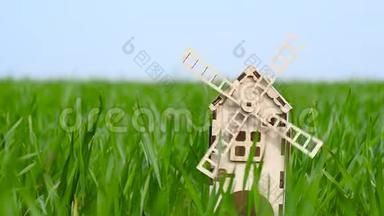 农业和农业。 一个用木头做的小装饰磨坊矗立在麦田的绿草中。